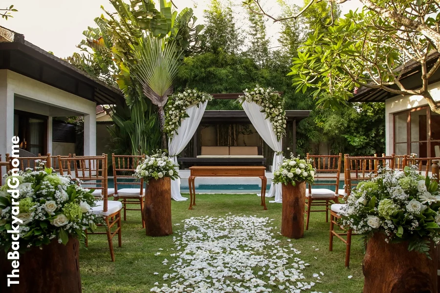 Beautiful romantic outdoor wedding setup in tropical garden, wooden chairs and simple gazebo decorated with white flowers - Part 2