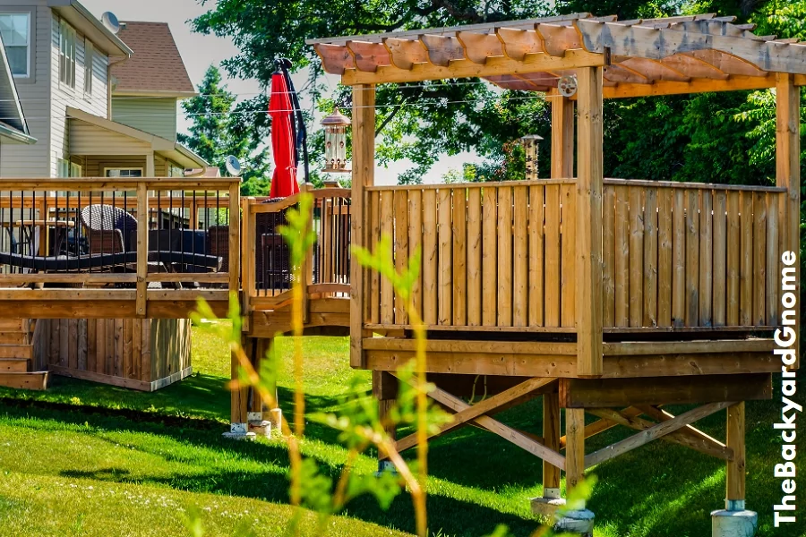 Raised backyard wooden deck and gazebo behind a row of houses